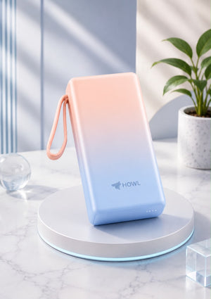 HOWL power bank standing upright showing the peach-to-blue gradient and silicone loop